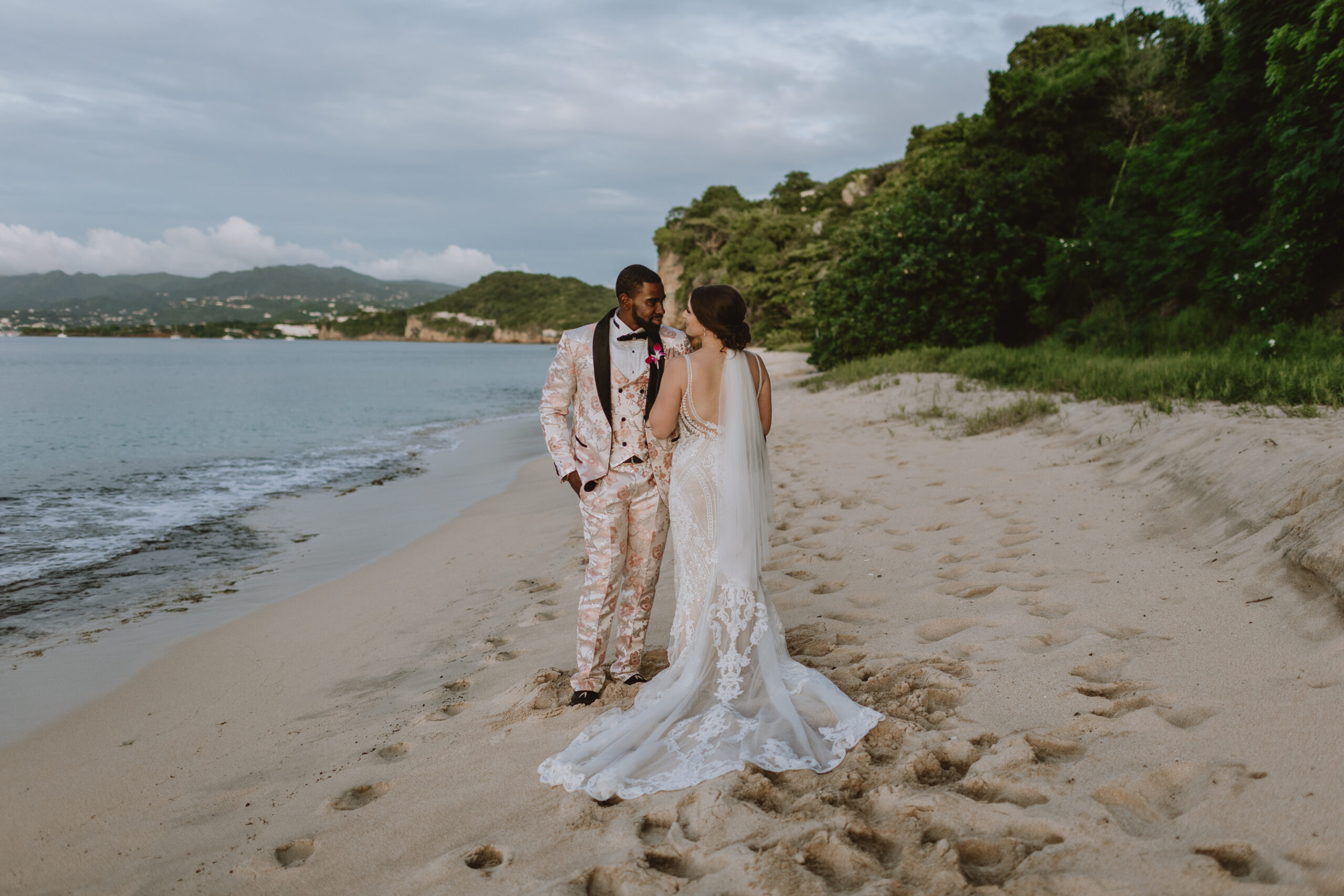 bride and groom standing on the beach