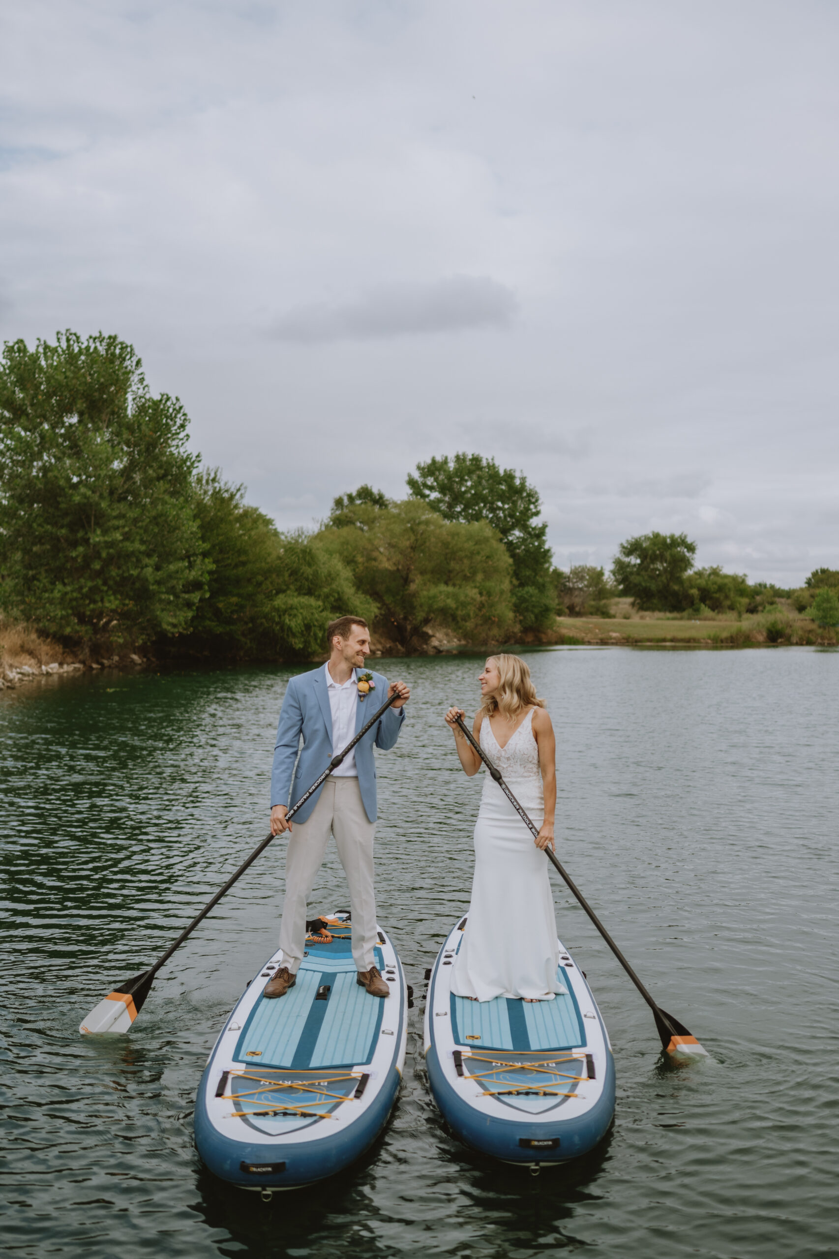 bride and groom on paddle boards