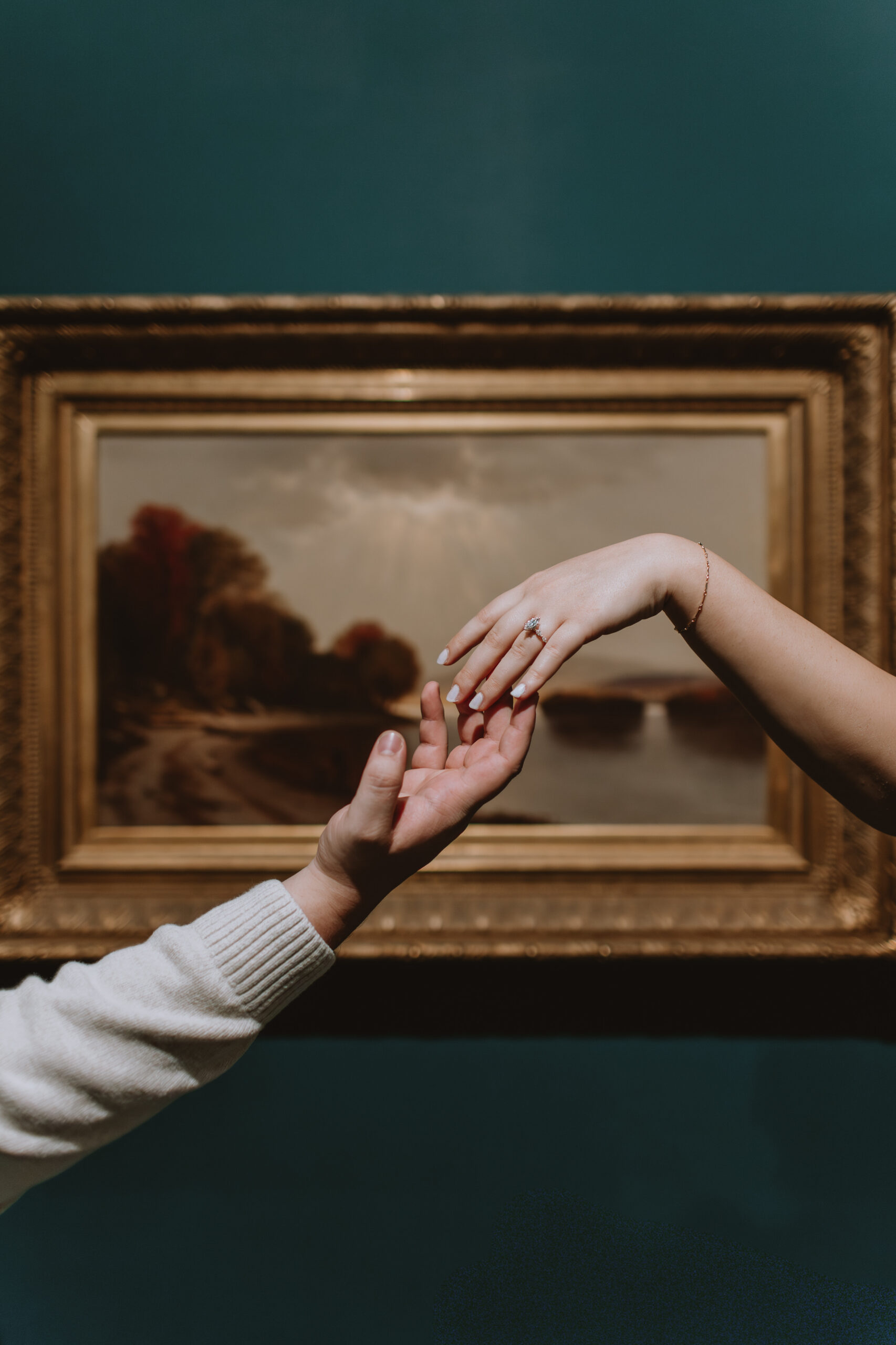 engagement ring in front of artwork