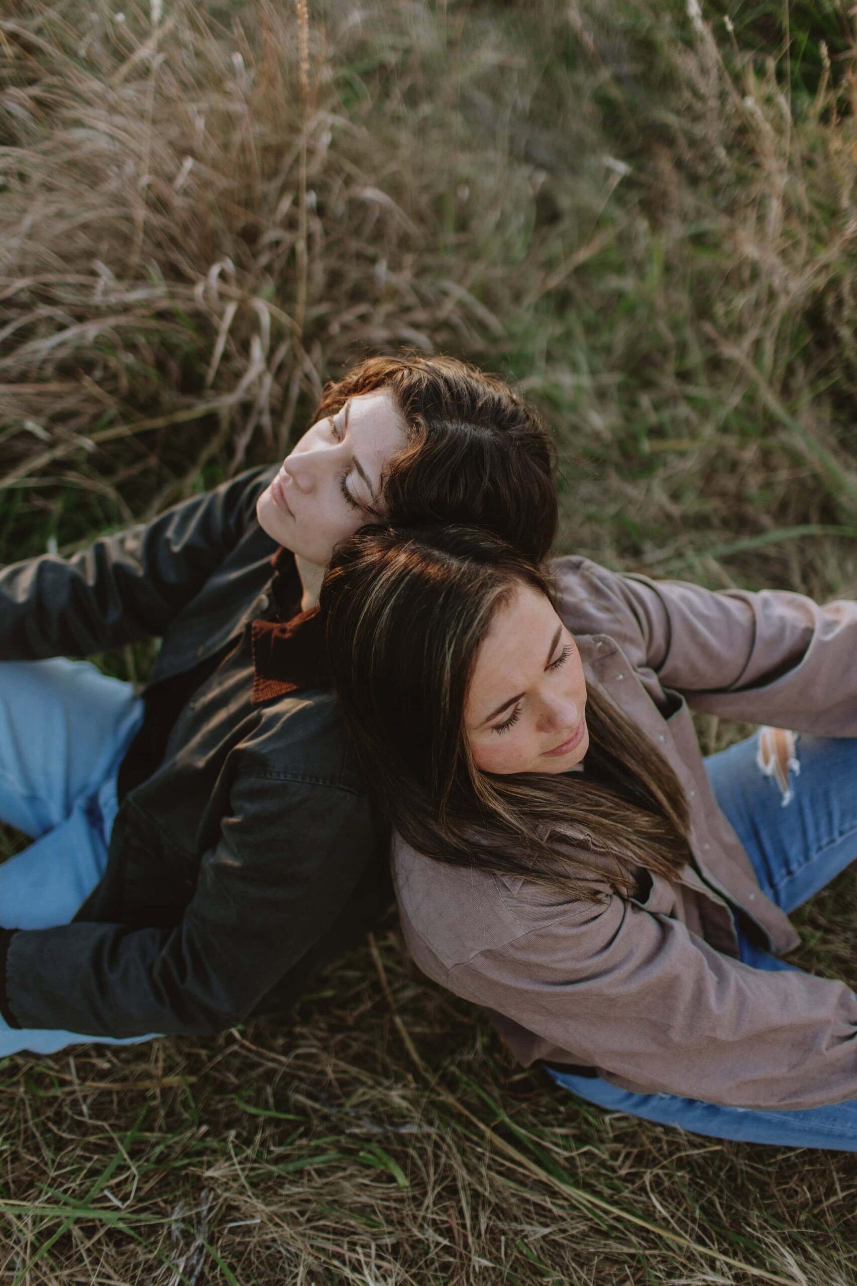 two women sitting in a field